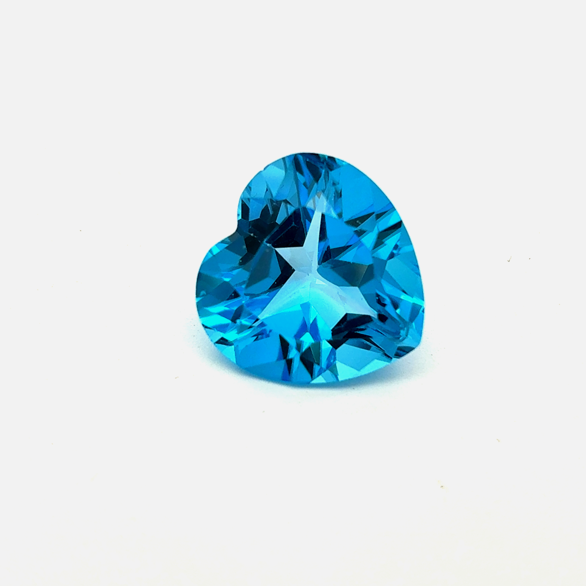 Heart-shaped blue gemstone(topaz) on a white background