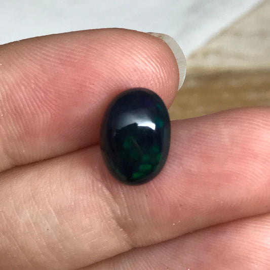 Black Opal 2.33 carat 11.8x8.7mm Oval Cabochon, Heat/Sugar  Enhanced Natural Opal