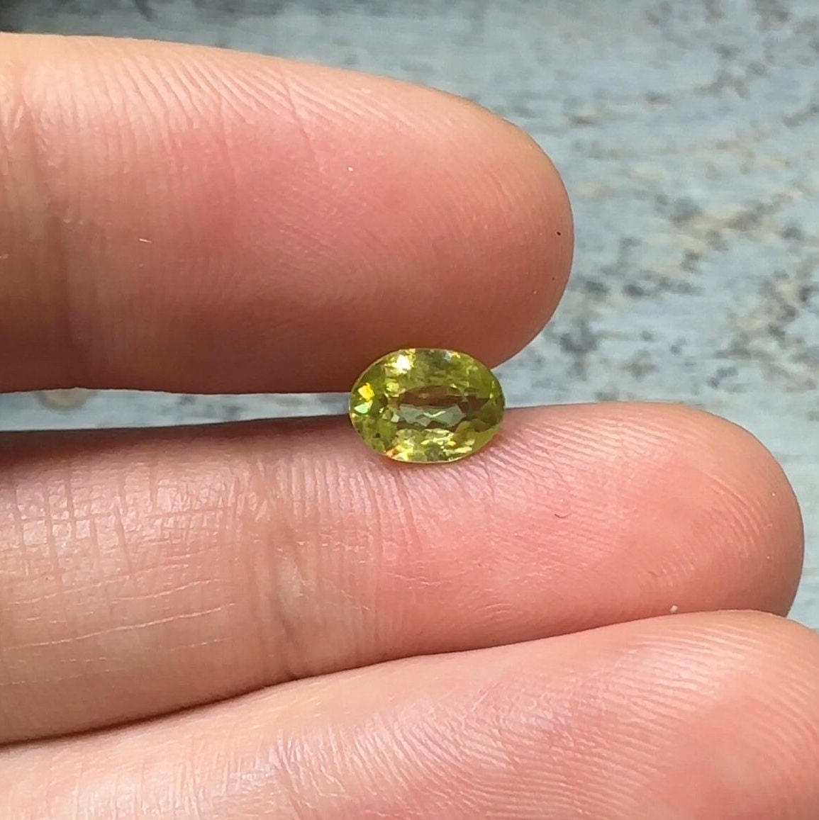 0.93 Yellow Green Sphene with Rainbow Flashes 7.3x5.3mm Oval Cut, Faceted Loose Titanite