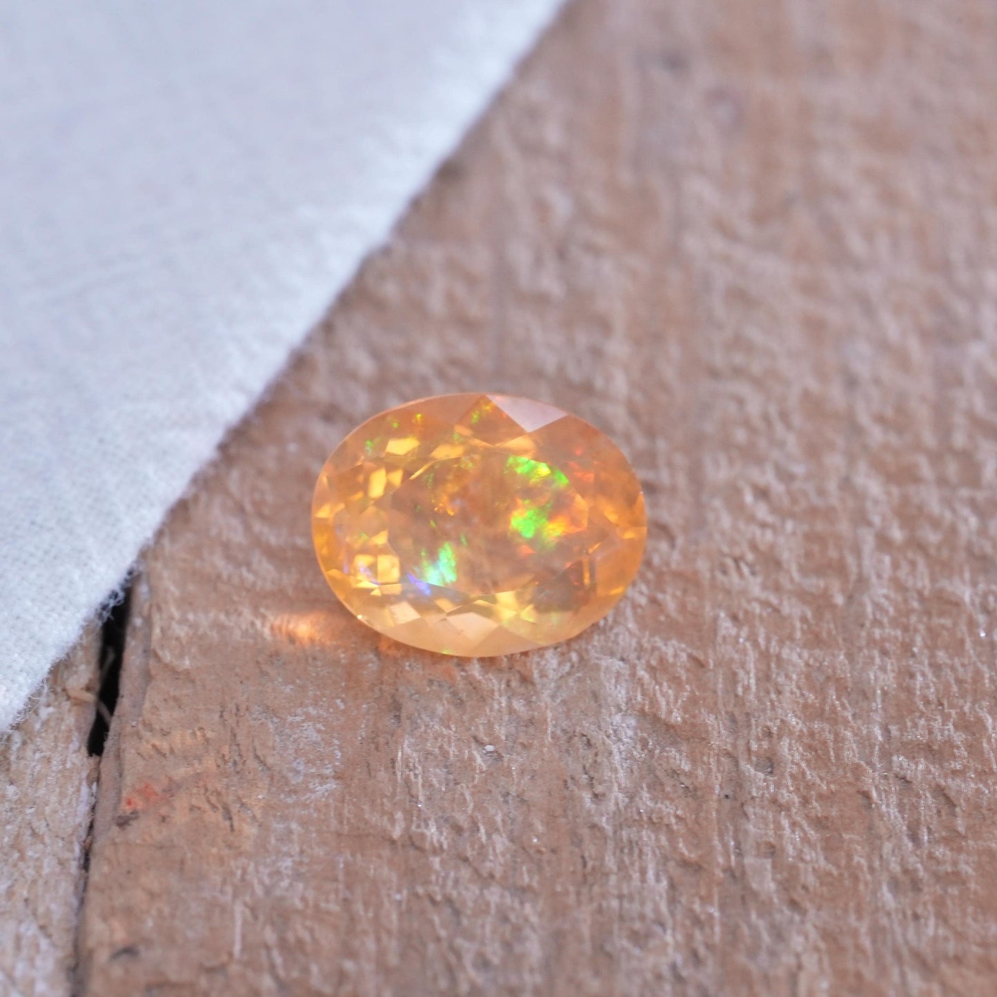 3.41 carat Orange Fire Opal with color play, 12.3x9.7mm Oval Cut